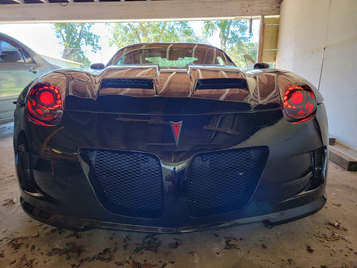 Black Pontiac Solstice with red halo headlights