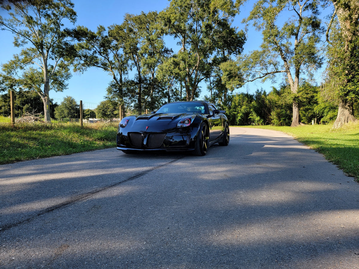 Black Pontiac Solstice with red halo headlights